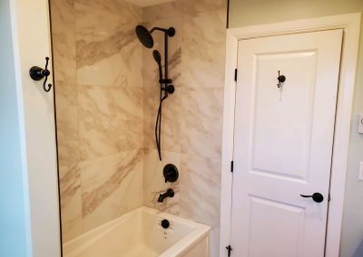 Bathroom with white door and bathtub